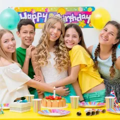 Uśmiechnięci nastolatkowie świętują urodziny przy stole pełnym balonów i tortu. W tle baner "Happy Birthday". Idealne konkursy zabawy na 50 urodziny!