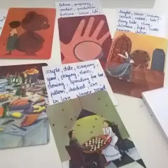 Karty z ilustracjami i notatki z hasłami: "dixit pomysły na hasła", uczta, rycerz, dzieciństwo, para grająca w szachy.