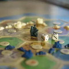 Figurki, osady i kostki na planszy do gry. Mądre gry wymagają strategii i odrobiny szczęścia.