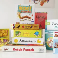 Stos kolorowych pudełek z grami planszowymi, idealnych na szybkie gry planszowe. Widać m.in. "Nogi Stonogi", "Ubongo" i "LATO z Komarami".