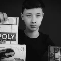 Chłopiec prezentuje gry: Monopoly, kółko i krzyżyk, bilard. Idealna gra dla jednej osoby, by rozwijać umiejętności.