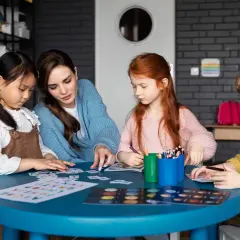 Nauczycielka i dzieci grają w gry edukacyjne. To wspaniały dzień planszówek, pełen nauki i zabawy.