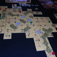 Plansza do gry Carcassonne: Safari. Rozłożone kafelki tworzą mapę sawanny z drogami i zwierzętami.