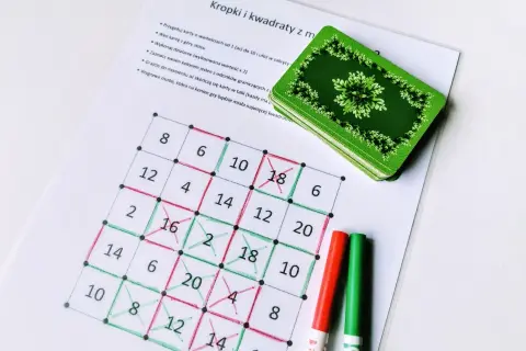 Gra "Kropki i kwadraty" z kartami. Na planszy z liczbami zaznaczone są zielone i czerwone **kropki kreski**, tworząc kwadraty.