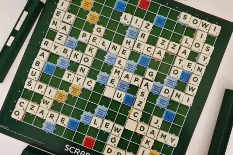 Plansza do gry Scrabble z ułożonymi słowami, pokazująca zasady gry i pola premiowe.