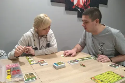 Para dowiedzieć się, jak się gra w planszówkę, obserwuje karty i planszę.