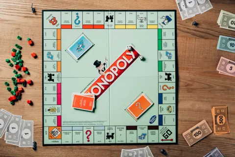 Plansza do gry Monopoly, pionki, domki i pieniądze. Kto pierwszy zdobędzie dublet w Monopoly?