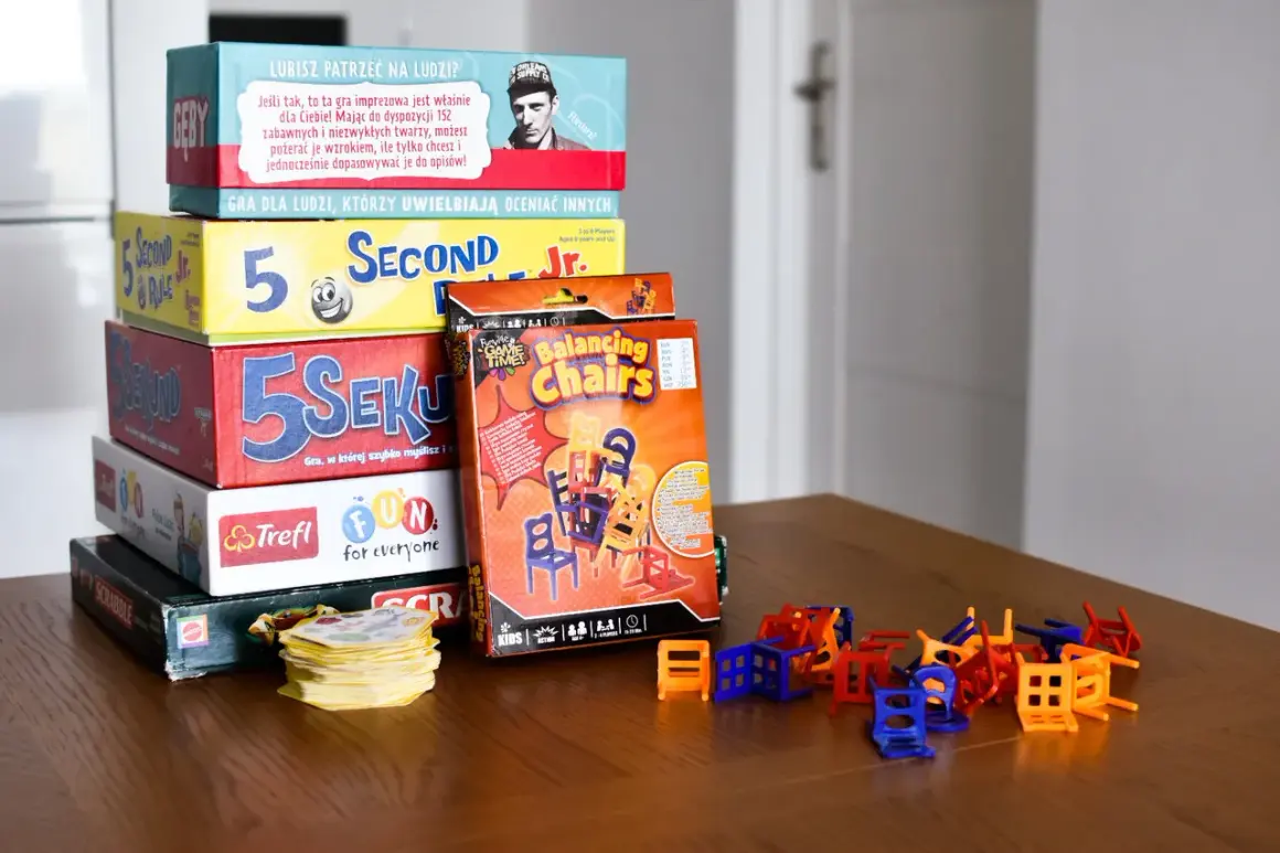 Stos pudełek z popularnymi grami dla dzieci: "5 Sekund", "Balancing Chairs", "Scrabble" i inne. Idealne na rodzinne wieczory.